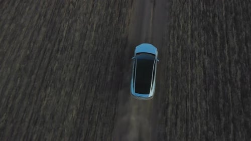 Aerial View of Electrical Car Driving Through Country Road