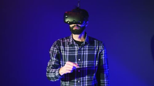 Bearded Man Using Virtual Reality Headset at Modern Office with Blue Background