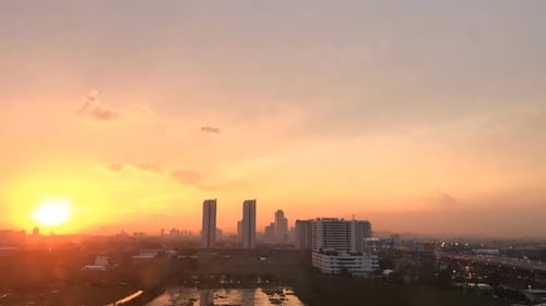 Sunset cloudy sky time lapse on downtown cityscape building in the evening