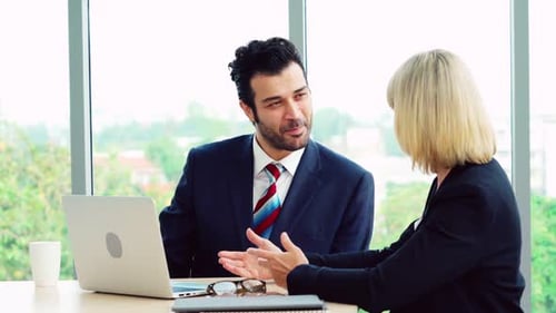 Two Business People Talk Project Strategy at Office