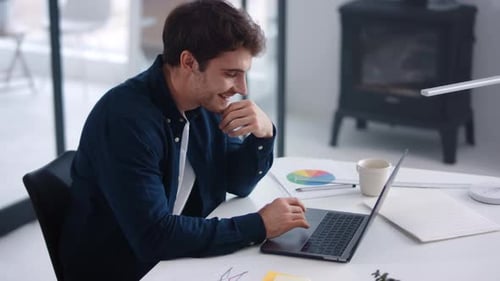 Young Adult Man Working on Laptop in Modern Office