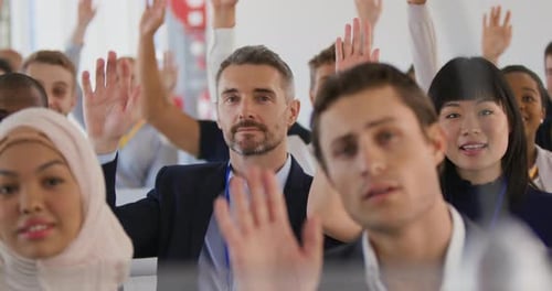 Diverse Group Raises Hands at Corporate Event