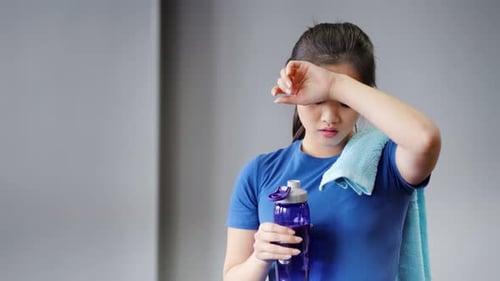 Young Woman Drinks Water After Exercising