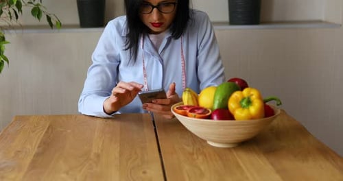 Woman Uses Phone with Bowl of Healthy Food
