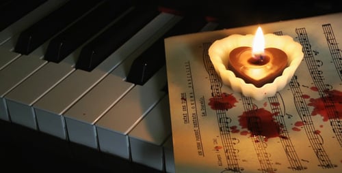 Candlelit Sheet Music on Piano Keys with Splatter