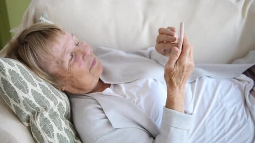 Senior Woman Reclining and Using Cell Phone