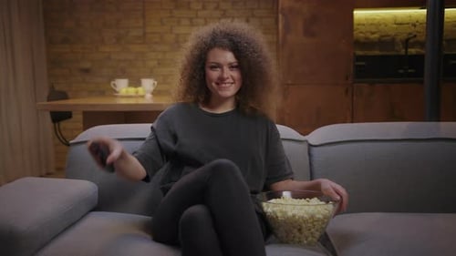 Woman Relaxes on Couch with Popcorn