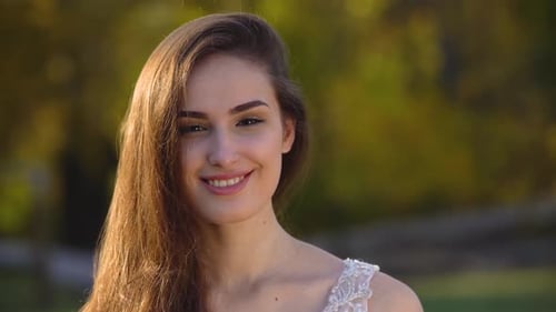 Portrait of Beautiful Brunette Bride with Deep Look Is Looking Right and Begins To Smiling in Sunny