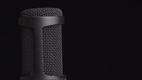 Studio Condenser Microphone Rotates on Black Background with Place for Text