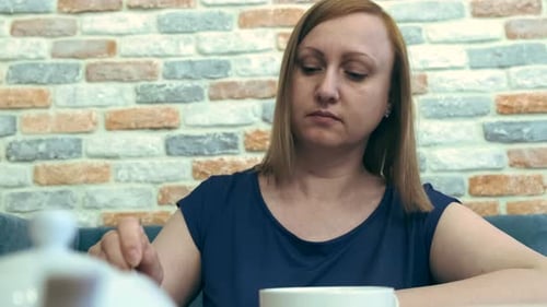Woman Drink Tea and Eats Cake in Cafe.