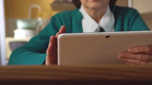Adult Using Tablet at Wooden Table Indoors