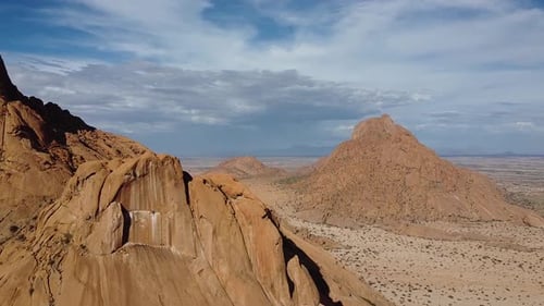 Montañas rocosas en el desierto cubiertas de pequeñas plantas del desierto, toma aérea
