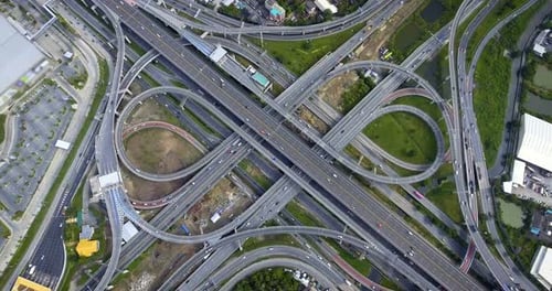 Aerial View of Highway Road Interchange with Busy Urban Traffic Speeding on Road