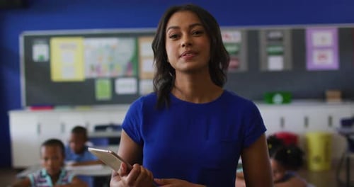 Woman Smiling with Tablet in Classroom Setting