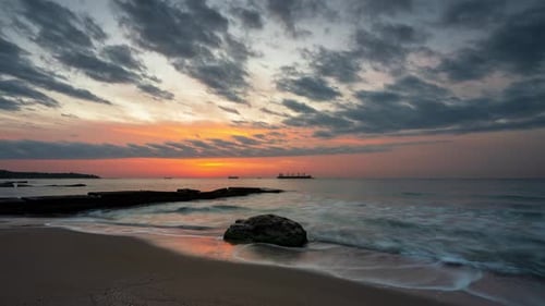 Timelapse with the rising sun at a beautiful sandy coast