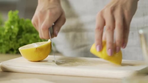 Nahaufnahme Frauenhände schneiden gelbe Zitronen, frische Limonade kochen