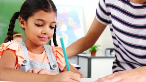 Teacher Helping Student in Elementary School Classroom