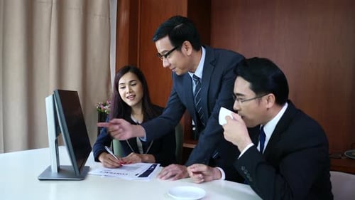 Geschäftsleute arbeiten zusammen am Schreibtisch und überprüfen einen Finanzbericht.