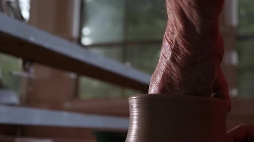 Hands Shaping Clay on Pottery Wheel in Studio