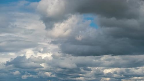 Zeitrafferaufnahmen von sich schnell bewegenden weißen, geschwollenen Cumulus-Wolken am blauen, klaren Himmel