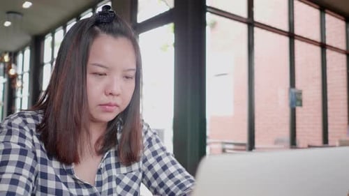 Freelancer Asian woman using laptop online working in coffee shop