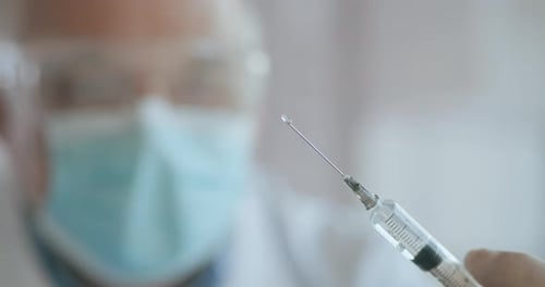 Arzt bereitet Spritze vor. Arzt bereitet Spritze für die Injektion vor. Ärztin oder Krankenschwester Holding