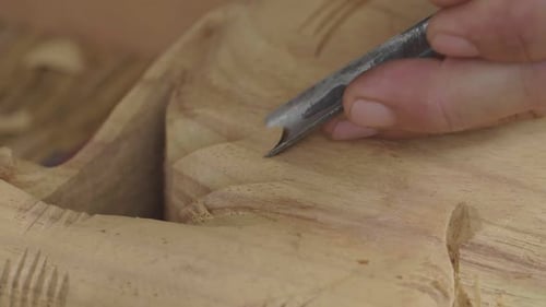 Hands Carving Intricate Wood Design with Sharp Tool