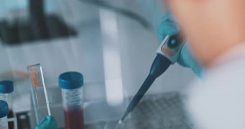 Scientist Dispenses Liquid into Tray in Laboratory