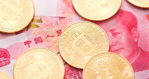 Bitcoin Coins on Top of Chinese Yuan Banknotes
