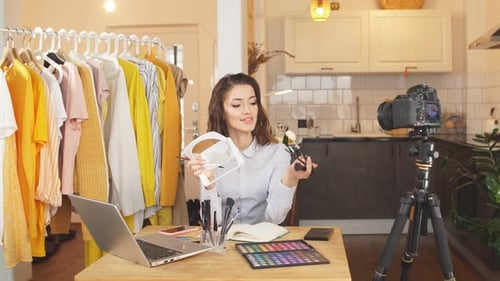 Joven bloguera se maquilla ante la cámara, muestra su maquillaje diario a los suscriptores, trabajo remoto