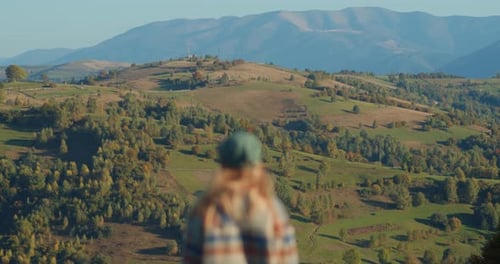 Woman hiker walking up grassy hill