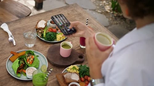 Woman Snapping Food Photo at Outdoor Table