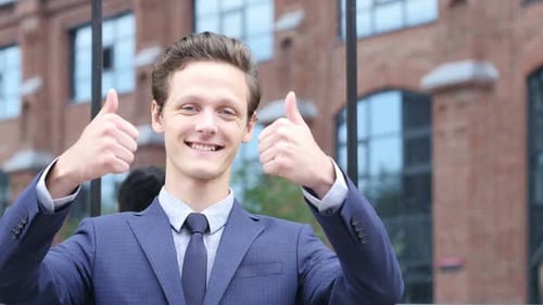 Smiling Young Adult Giving Two Thumbs Up
