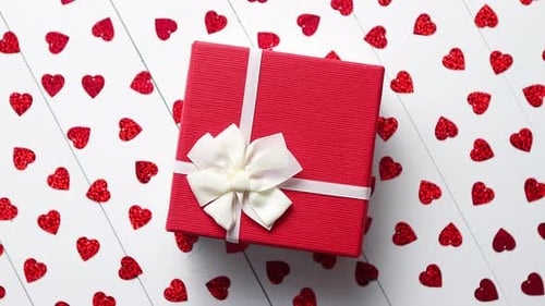 Red Gift Box Surrounded by Red Hearts