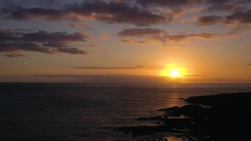 Aerial View of the Atlantic Ocean and the Rocky Coast on the Background of a Beautiful Sunset
