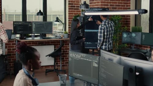 System Developers Analyzing Code on Wall Screen Tv Looking for Errors