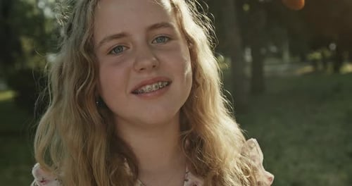 Young Girl with Dental Braces Standing in Park