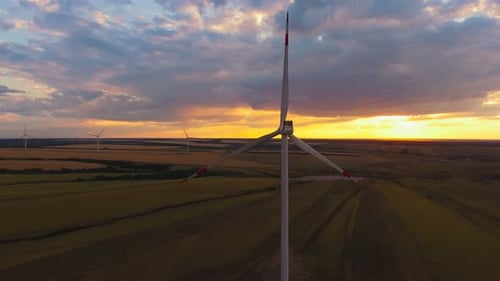 Aerial view. The wind farm is working against the backdrop of a beautiful sunset.