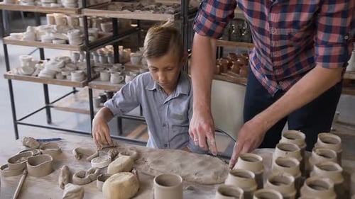 Boy and Adult Create Pottery in Bright Studio