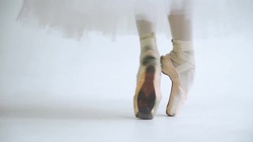 Female in a White Tutu, Dance Ballet and Balancing in Pointe Shoes, View of the Legs, White