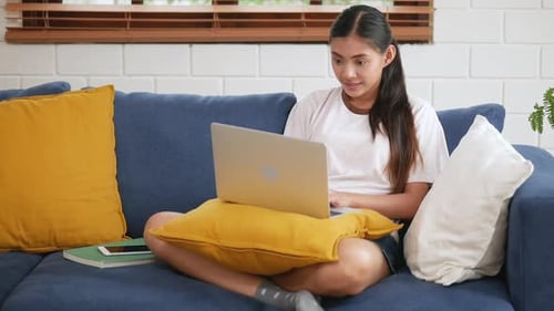 Woman Using Laptop on Couch at Home
