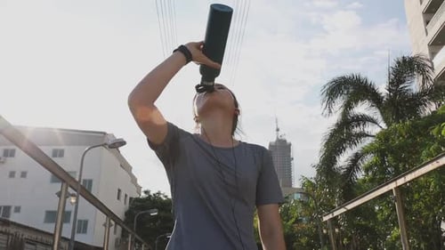 Woman Drinking Water in Urban Environment