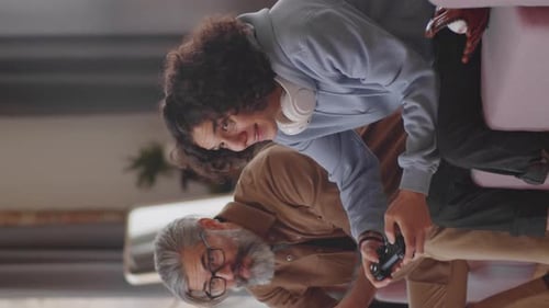 Senior Man and Young Adult Enjoying Video Games