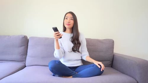 Excited Young Woman Watching Television at Home