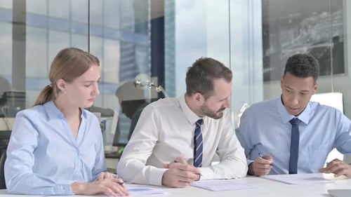 Executive Business People Sharing Information Through Documents on Office Table