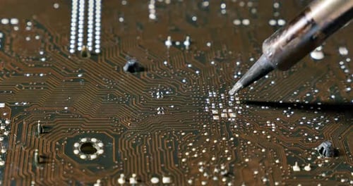 Soldering a Circuit Board with a Soldering Iron. Close-up Shot of Repair at Computers and