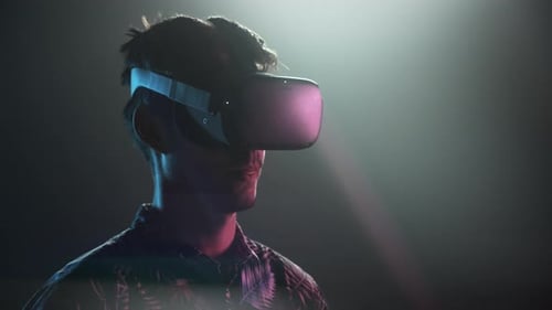 Man Wearing Virtual Reality Headset in Dark Room