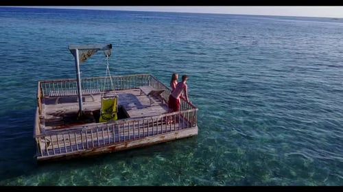 Man and woman sunbathing on tranquil seashore beach voyage by blue sea and clean sand background of