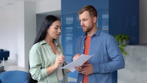 Two Business People Discussing About Work in an Office
