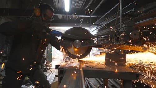 Worker Cutting Metal with Sparks Flying in Workshop